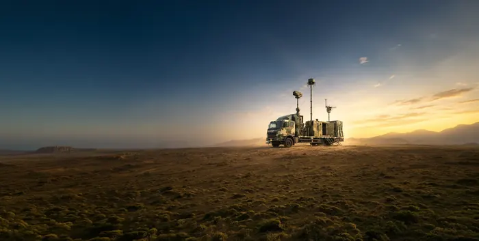 A containerised Zen anti-drone system mounted on a vehicle at dusk, with its radar and antenna mast raised.