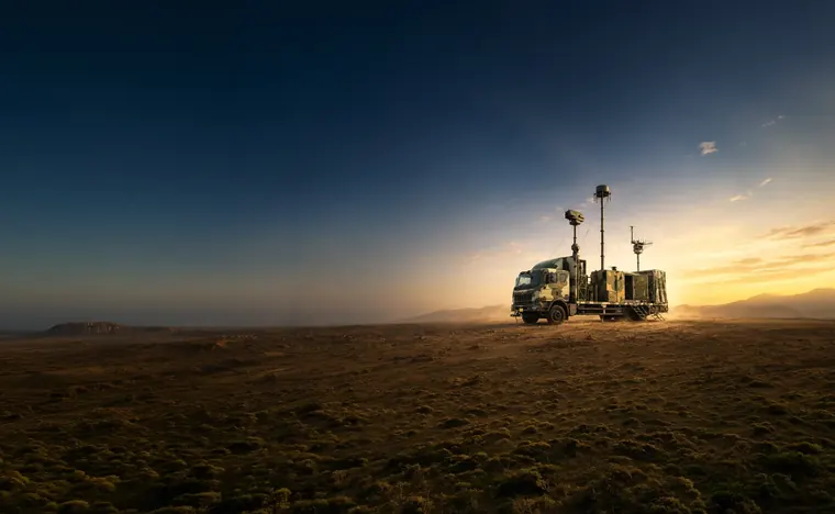 A containerised Zen anti-drone system on a vehicle in open desert at sunset.