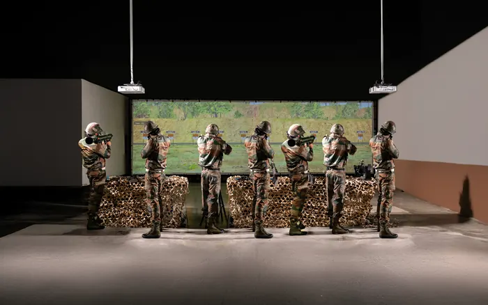 Soldiers at a Zen infantry weapons training simulator, firing at a projected range.